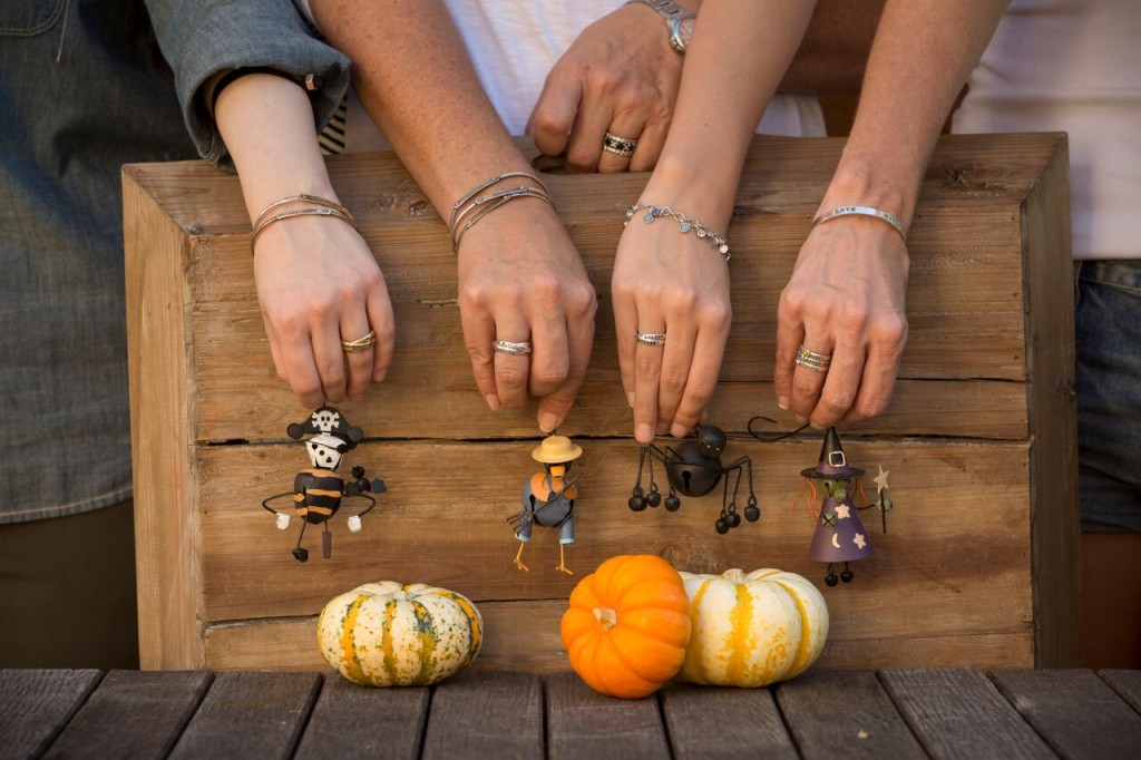 hands with jewelry holding toys and pumpkins